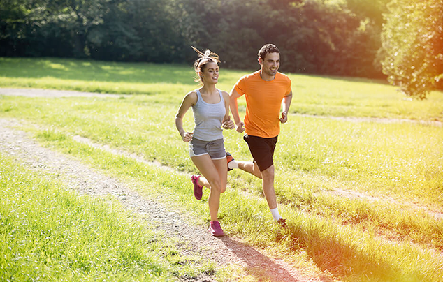 Una coppia si allena facendo running in un sentiero tra la natura