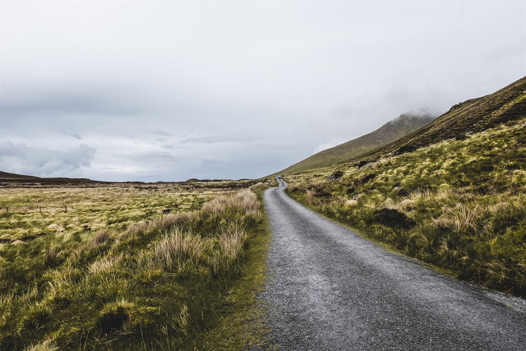 CATERINA BELEFFI IN GAELICO AN CHONAIR, IN INGLESE CONNOR PASS E IN ITALIANO PASSO CONOR. LA MIA GUIDA TASCABILE MI INFORMA CHE SI TRATTA DI UNO DEI PASSI MONTANI PIÙ ALTI DELL’ISOLA D’IRLANDA. ALTITUDINE: 456M SOPRA AL LIVELLO DEL MARE. UNA DIMENSIONE BEN RIDOTTA SE LA COMPARIAMO A QUELLE DELLE NOSTRE CATENE MONTUOSE. CIONONOSTANTE IL PERCORSO VERSO LA VETTA NON È DEI PIÙ SEMPLICI, LA STRADA È LARGA QUANTO UNA PICCOLA VETTURA, COSTEGGIATA DA UN’IRREGOLARE MURETTO IN PIETRA E IN CASO DI PRECIPITAZIONI PUÒ ESSERE DAVVERO PER