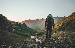 Persona Che Cammina in Montagna Con Uno Zaino