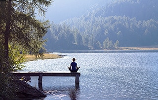 Persona Che Pratica Meditazione Vicino a Un Lago