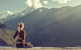 Ragazza pratica yoga in montagna