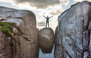 Uomo in bilico su una roccia