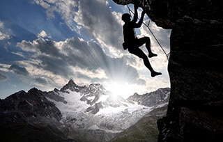 Uomo che scala una montagna